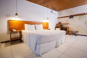 a bedroom with a white bed and white walls at CASA Di VINA Boutique Hotel in Salvador