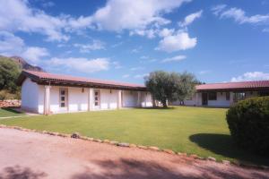 a building with a large lawn in front of it at Su Cappeddu Agriturismo in San Giorgio +8 photos