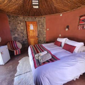 a bedroom with a large bed with towels on it at Masairi in San Pedro de Atacama