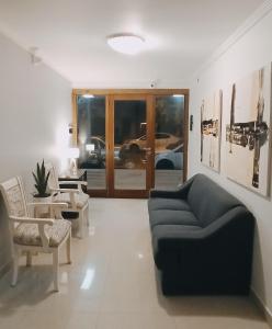 uma sala de estar com um sofá azul e cadeiras em Hotel Miceli em Bragado