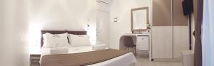 sypialnia z łóżkiem, biurkiem i lustrem w obiekcie Villa Orkidea w Sarandzie