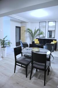 - un salon avec une table, des chaises et un piano dans l'établissement Apartament Royal, à Dej