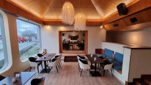 a restaurant with tables and chairs and a large window at Hotel Ikera in Hernando