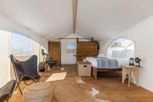 a bedroom with a bed and a chair in a tent at Under Canvas Moab in Moab