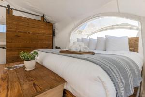 
a white bed with a wooden headboard and pillows at Under Canvas Moab in Moab
