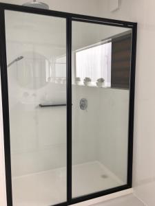 una ventana de cristal en un baño con dos macetas en The Birch Studio - BOUTIQUE ACCOMODATION - CENTRAL to WINERIES and BEACHES, en Leopold