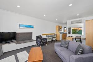 a living room with a couch and a tv at The Lakes Motel in Twizel