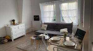 sala de estar con sofá y mesa en Petit cocon proche gare et commerces, en Chantilly