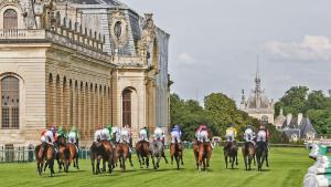 a group of jockeys riding horses in front of a building at Petit cocon proche gare et commerces in Chantilly