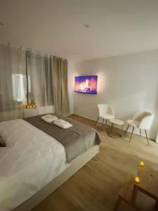 um quarto com uma cama, 2 cadeiras e uma mesa em L’appart[é] Gold em Besançon