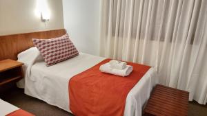 a bedroom with a bed with two towels on it at Hotel Ikera in Hernando