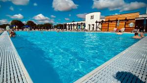 a large swimming pool with people in the water at The Luxury break Sleeps 6 at Kingfisher Court South facing in Tattershall