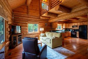 una sala de estar con sofá y una cocina en una cabaña de madera en The Log Cabin home, en Stevenson