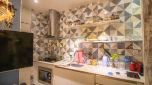 a kitchen with a sink and a tiled wall at Pôr do Sol Apartamento in Salvador