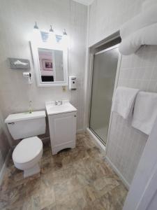 Holiday Lodge في شيريدان: حمام ابيض مع مرحاض ودش
