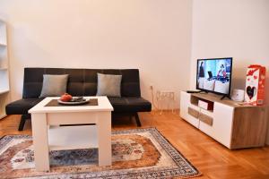 a living room with a couch and a table at Apartman Roses in Lukavica