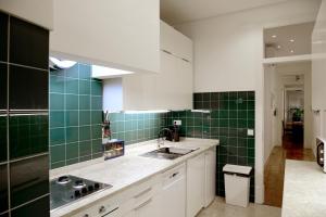 a kitchen with green tiles on the walls and a sink at My Apartment in Lisbon