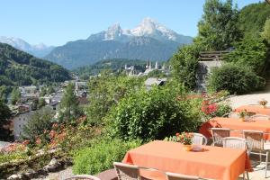a table and chairs with mountains in the background at Hotel Krone in Berchtesgaden