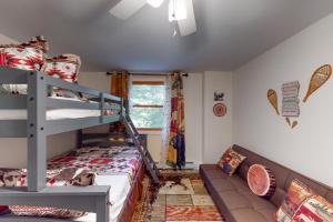 a bedroom with a bunk bed and a couch at Magic Birch Lodge in Windham