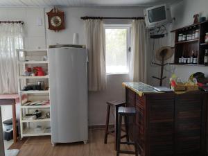 a kitchen with a refrigerator and a desk and a window at Recanto das Videiras in Maria da Fé