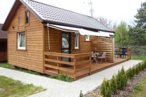a wooden cabin with a deck and a table at Holiday resort, Wiselka in Wisełka