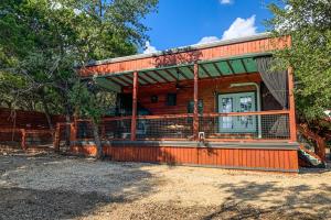a log cabin with a fence in front of it at Chimney Rock Tiny Home in Canyon Lake