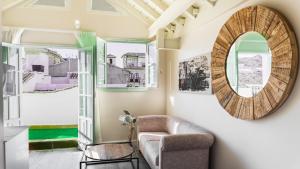 a living room with a chair and a mirror at 4U Suites in Granada