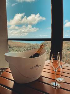 a bottle of champagne in a bath tub on a table with wine glasses at Miragem Noronha in Fernando de Noronha