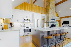 a kitchen with white cabinets and a large island with bar stools at Tuckerman Tollhouse in Jackson