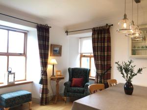 a living room with a chair and a table at Glenmuir Cottage in Dornoch