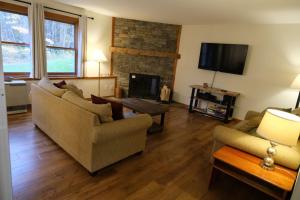 a living room with two couches and a fireplace at Trail Creek: Walk to lifts, ski home! Closest unit to lifts, ski home trail, sports center in Killington
