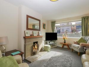 a living room with a fireplace and a television at Home View in Coleford