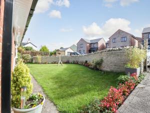 a backyard with a retaining wall and flowers at Home View in Coleford