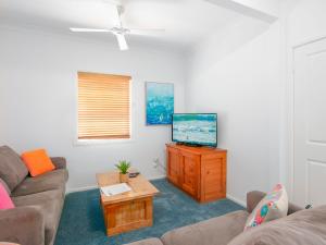 a living room with a couch and a flat screen tv at Avalon 2 in Yamba