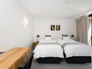 Duas camas num quarto com paredes brancas em The Rocks Resort Unit 8G em Gold Coast