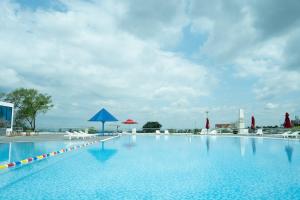 a large swimming pool with chairs and umbrellas at Elephants Hotel in Buon Ma Thuot