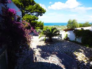 a stone walkway with a view of the ocean at Residenza Collina Dei Pini in Vieste +42 photos
