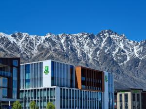 un edificio con montañas cubiertas de nieve en el fondo en Holiday Inn Queenstown Remarkables Park, en Queenstown
