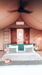 a bed in a tent with a hat on it at Autentik Penida "Glamping" - Adults only in Nusa Penida