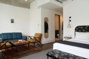 a bedroom with a bed and a couch and a table at Hotel Monopoli in Jakarta