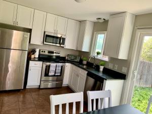 a kitchen with white cabinets and stainless steel appliances at Your home close to Anshutz and DIA in Aurora