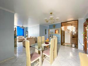 a dining room and living room with a glass table and chairs at Apart 4 quartos Praia do Forte e Canal in Cabo Frio