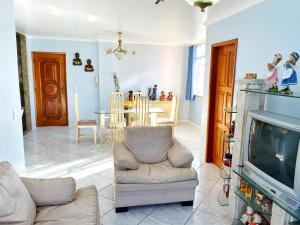a living room with a couch and a tv at Apart 4 quartos Praia do Forte e Canal in Cabo Frio