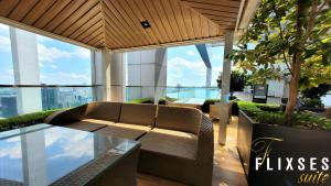 salon z kanapą w budynku z oknami w obiekcie Flixses Suites at Platinum KLCC w Kuala Lumpur