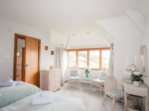 a bedroom with two beds and a table and chairs at Bryn Y Mor, Borth Y Gest in Porthmadog