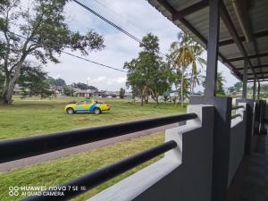 a yellow and blue car parked in a field at SingLeisure Holiday House in Mersing