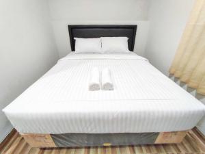 a bed with two wedding shoes on top of it at Maita Homestay Ringroad Utara Mitra RedDoorz in Kejayan