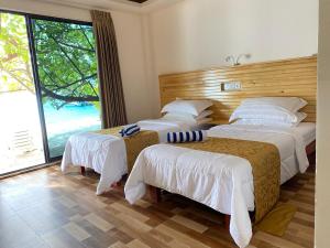 Łóżko lub łóżka w pokoju w obiekcie Paguro Seaview