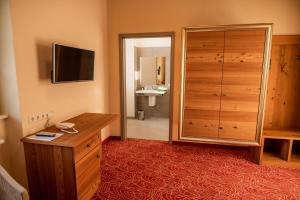 Zimmer mit einer Kommode und einem Schrank mit einem Spiegel in der Unterkunft Hotel Freyhof in Freiberg