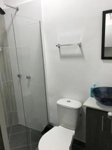 a bathroom with a toilet and a glass shower at Aparta estudio amoblado Medellin, San joaquin in Medellín